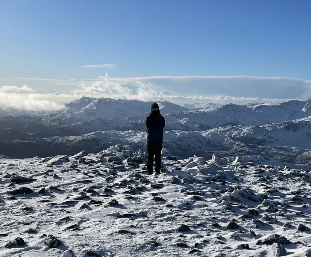 A well prepared walker on top of a snow-covered mountain