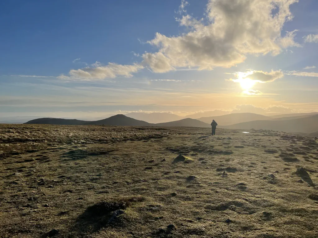 On a mountain top looking towards a setting sun