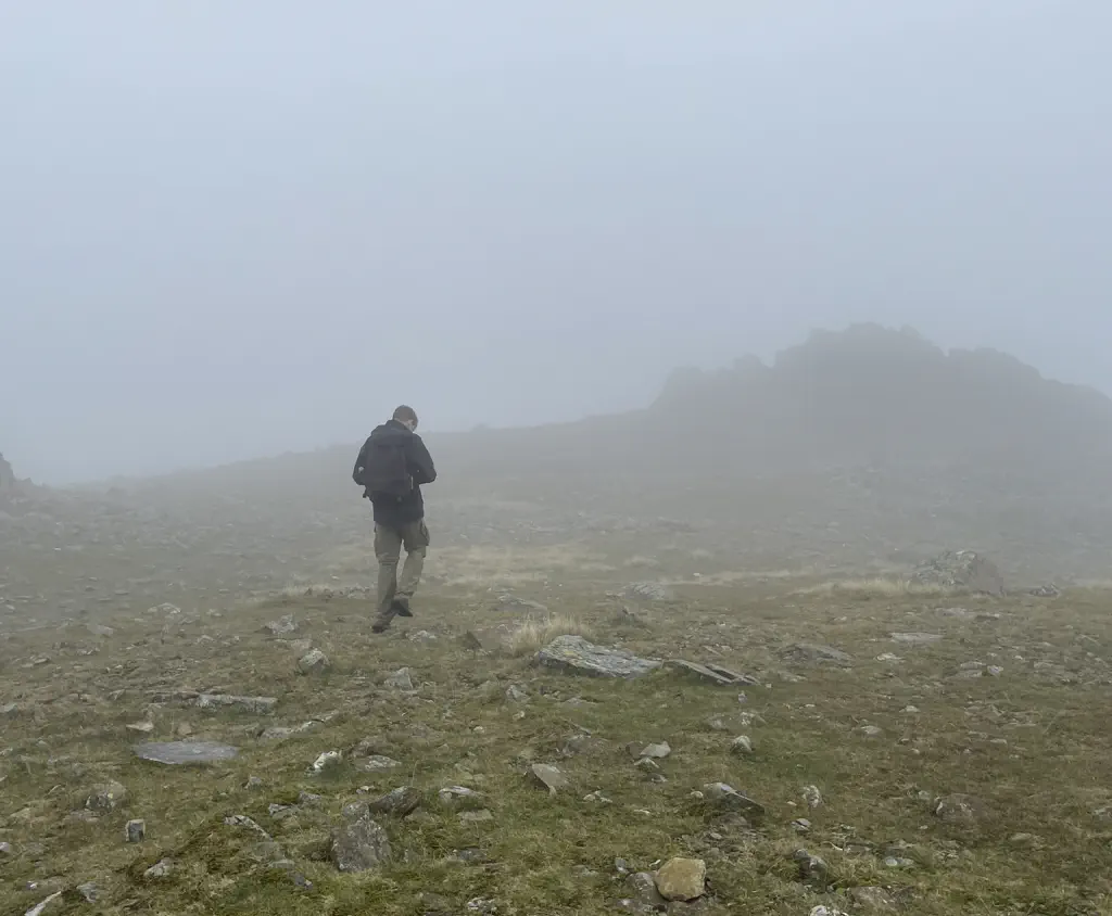 A walker navigating through a foggy mountaintop