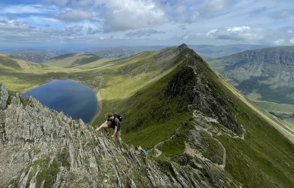 A climber scrambling the final section of Striding Edge
