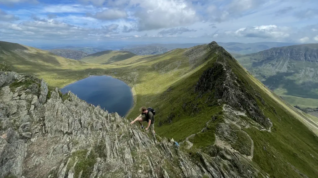 A climber scrambling the final section of Striding Edge