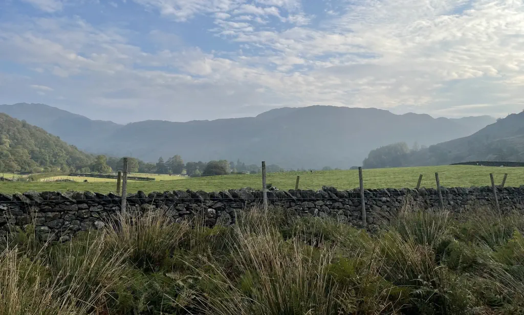 Misty morning mountains behind a cobblestone wall